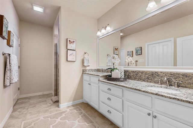 bathroom featuring a sink, baseboards, and double vanity