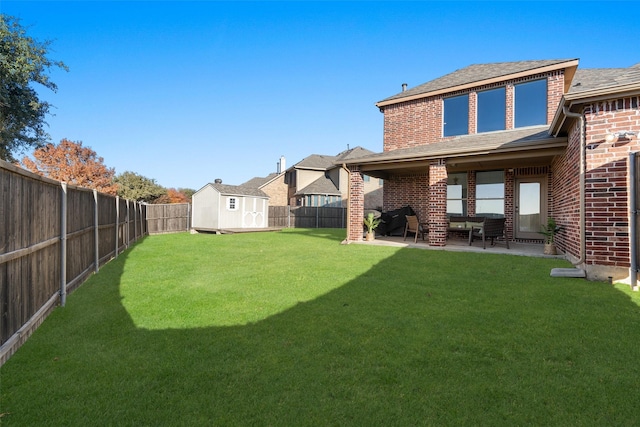 rear view of property with brick siding, a patio, a shed, roof with shingles, and an outdoor structure
