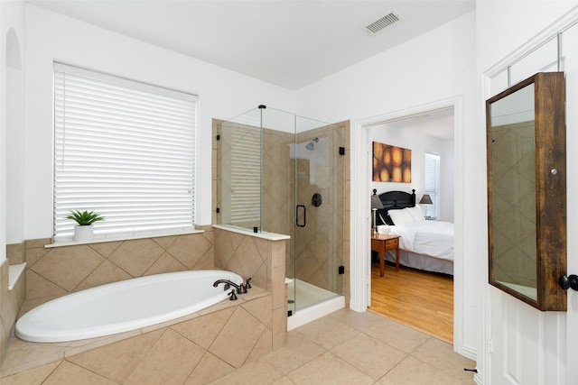 bathroom with ensuite bathroom, a shower stall, a bath, and tile patterned flooring