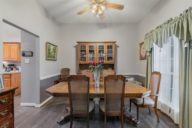 dining room featuring dark wood-style floors, baseboards, and a ceiling fan