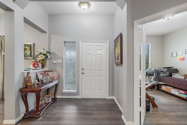 entryway with dark wood finished floors and baseboards