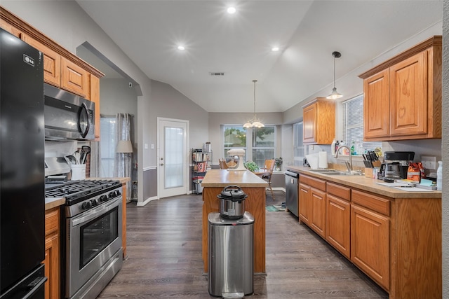 kitchen featuring visible vents, a kitchen island, appliances with stainless steel finishes, light countertops, and a sink