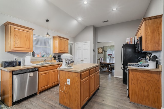 kitchen with light countertops, visible vents, stainless steel dishwasher, a kitchen island, and a sink