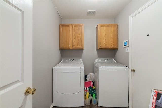 washroom featuring cabinet space, visible vents, and washing machine and clothes dryer