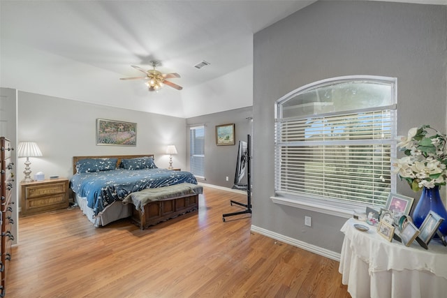 bedroom with baseboards, visible vents, a ceiling fan, wood finished floors, and vaulted ceiling