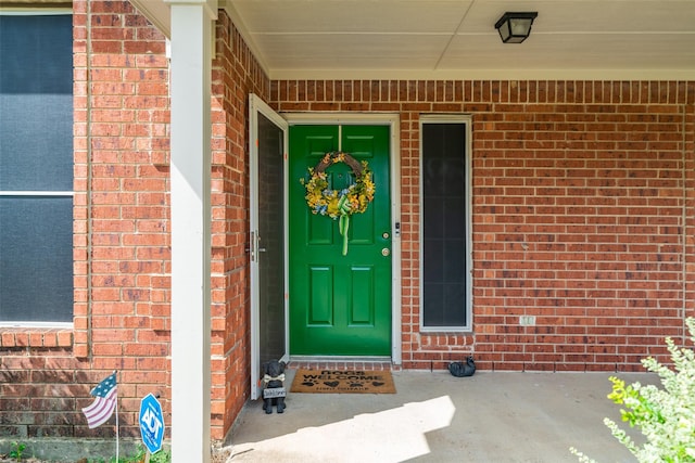 view of exterior entry featuring brick siding