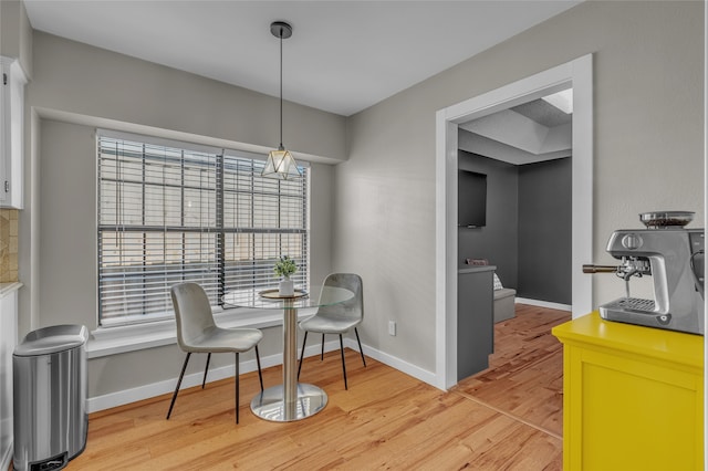 dining room with baseboards and light wood finished floors