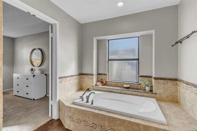 bathroom featuring wood finished floors and a bath