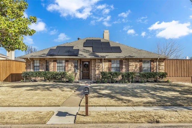 view of front of property with roof with shingles, fence, and brick siding