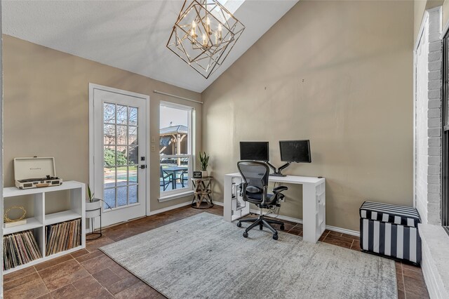 office space featuring a chandelier, stone finish floor, high vaulted ceiling, and baseboards