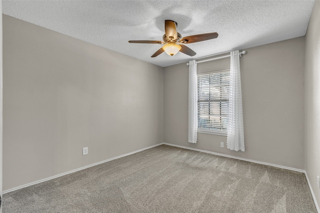 carpeted empty room featuring a textured ceiling, a ceiling fan, and baseboards