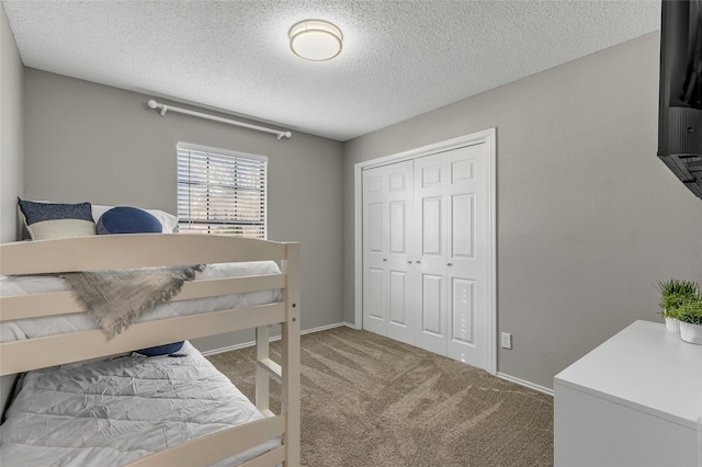 carpeted bedroom featuring a closet, a textured ceiling, and baseboards