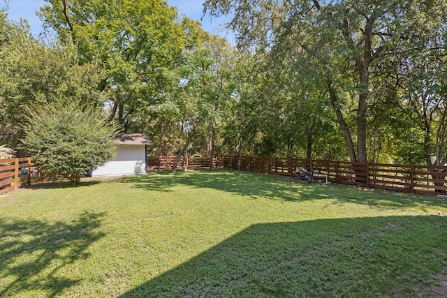 view of yard with a fenced backyard, an outdoor structure, and a storage shed