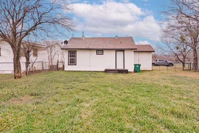 rear view of property with a yard and fence