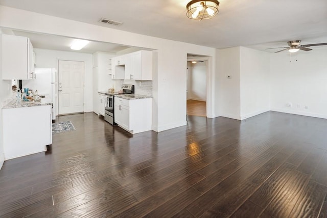 unfurnished living room featuring dark wood-type flooring, visible vents, ceiling fan, and baseboards