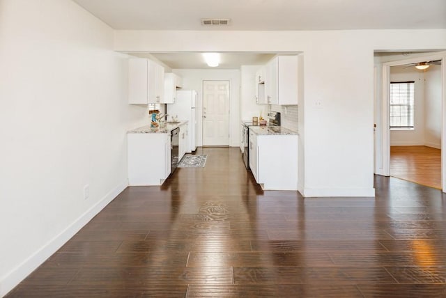 kitchen with dark wood-style floors, stainless steel electric stove, visible vents, decorative backsplash, and baseboards