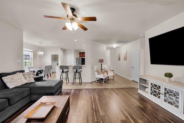 living room featuring baseboards, visible vents, ceiling fan, wood finished floors, and recessed lighting