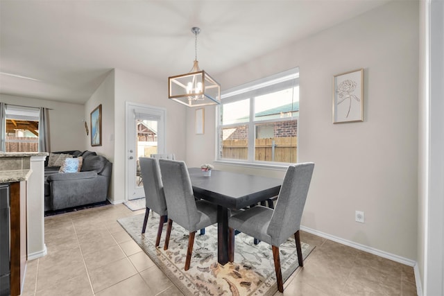 dining space with a chandelier, beverage cooler, light tile patterned floors, and baseboards