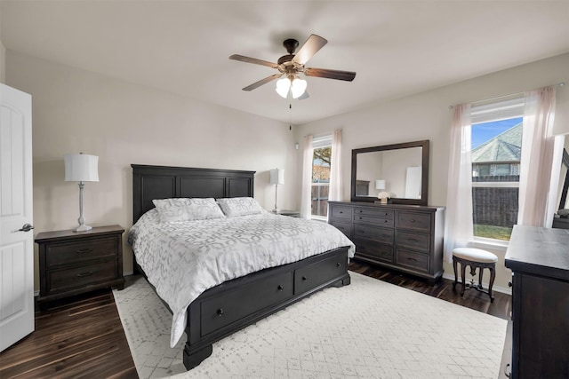 bedroom with ceiling fan, multiple windows, dark wood-style flooring, and baseboards