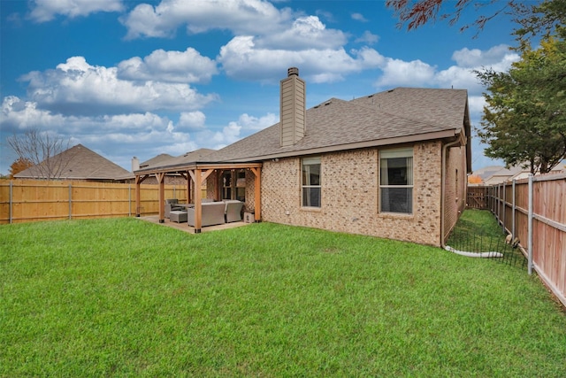 rear view of house featuring a fenced backyard, a yard, a chimney, and brick siding