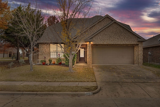 view of front of home with concrete driveway, a yard, and an attached garage