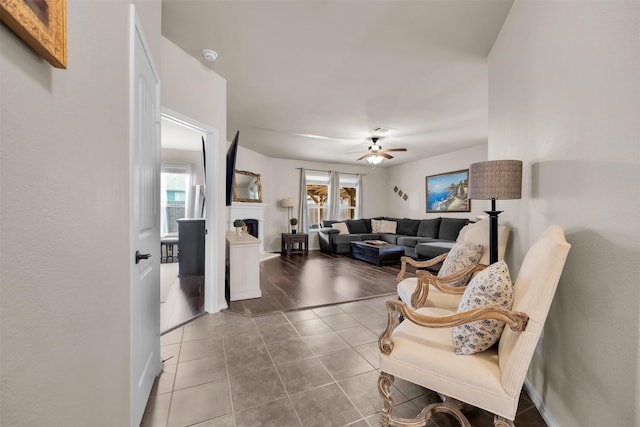 living area featuring visible vents, baseboards, ceiling fan, tile patterned flooring, and a fireplace