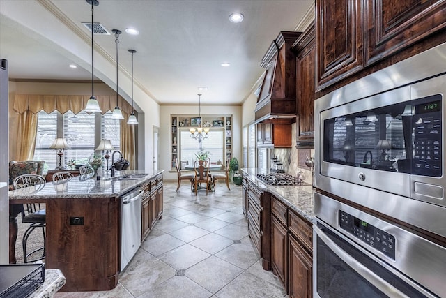 kitchen with stainless steel appliances, a breakfast bar area, a sink, and a wealth of natural light