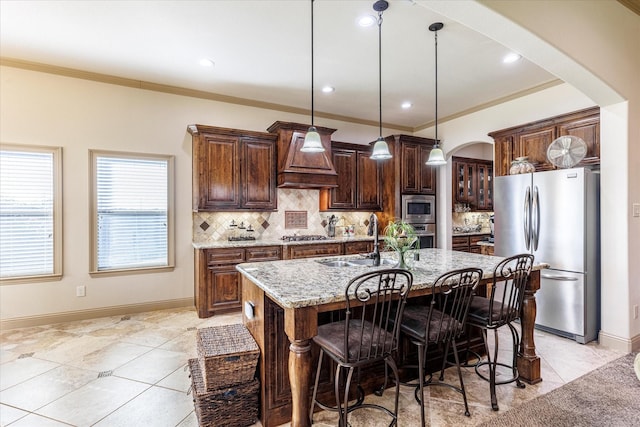 kitchen with arched walkways, appliances with stainless steel finishes, light stone countertops, custom exhaust hood, and a sink