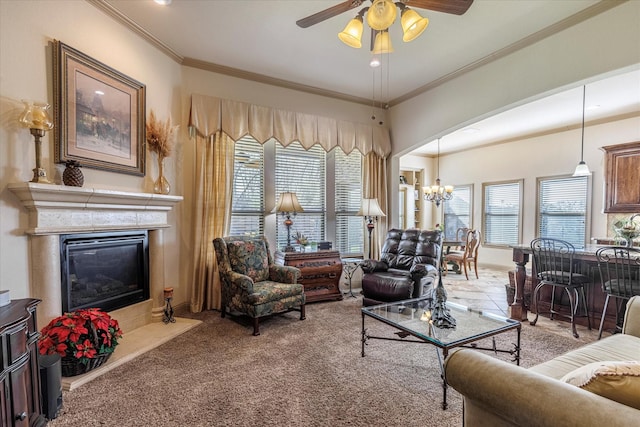 carpeted living room featuring ceiling fan with notable chandelier, a high end fireplace, and crown molding