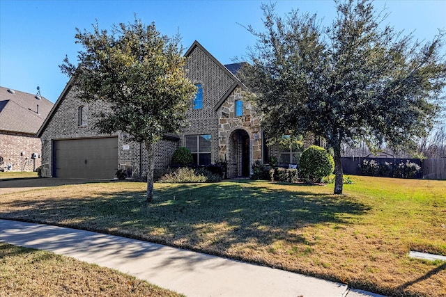 view of front of property with a garage, brick siding, fence, stone siding, and a front yard