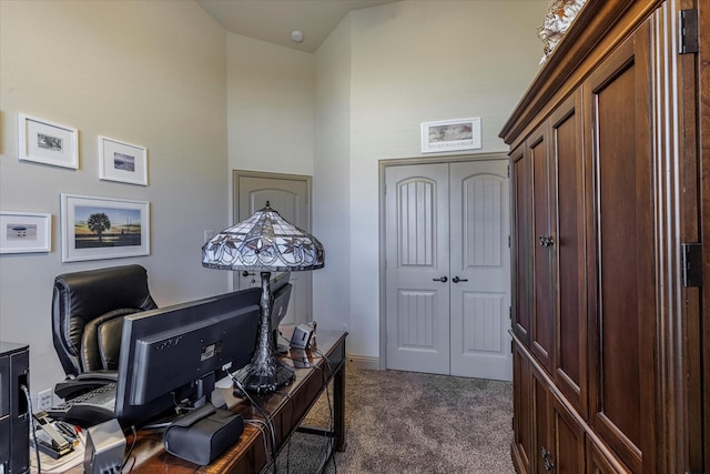 office area featuring a high ceiling and dark carpet