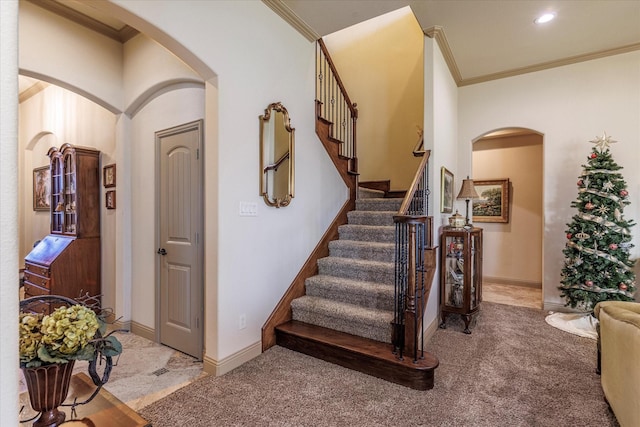 stairs with carpet, baseboards, and crown molding