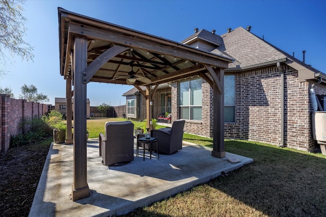 view of patio featuring a fenced backyard, an outdoor hangout area, a ceiling fan, and a gazebo