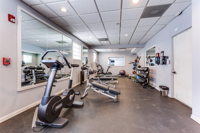 exercise room with recessed lighting, a drop ceiling, and baseboards