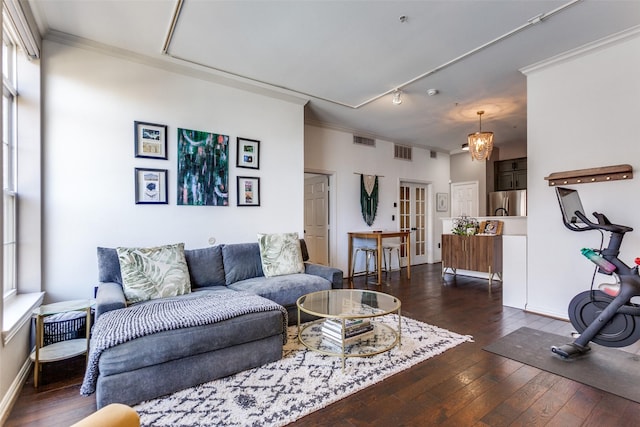 living room with dark wood-style floors, visible vents, a chandelier, and crown molding