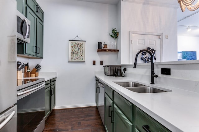 kitchen with a sink, light countertops, appliances with stainless steel finishes, dark wood-style floors, and green cabinetry