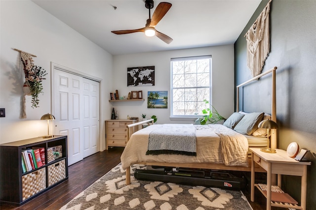 bedroom featuring dark wood-type flooring, a closet, and a ceiling fan