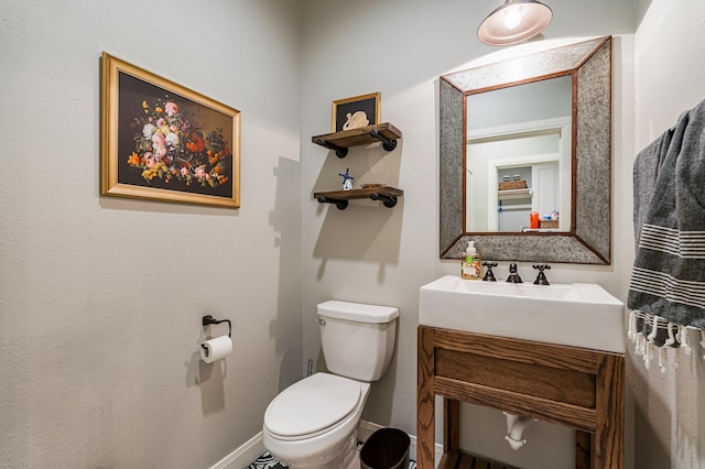 bathroom with baseboards, vanity, and toilet