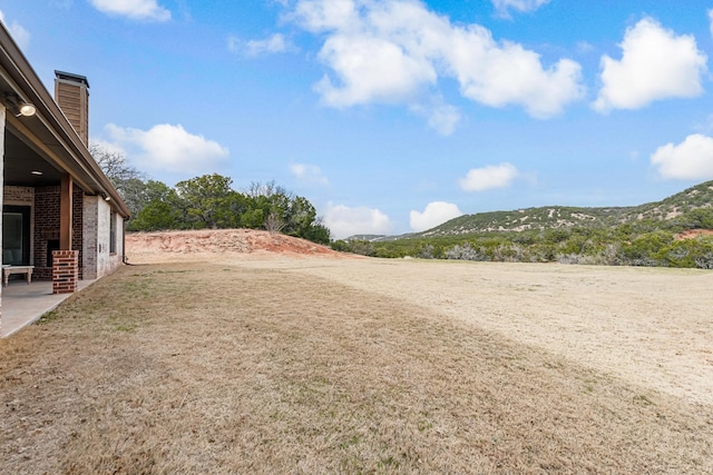 view of yard featuring a mountain view and a patio