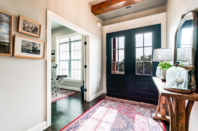 entryway with beam ceiling, visible vents, dark wood finished floors, and baseboards