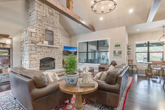 living room featuring dark wood-style floors, beamed ceiling, a stone fireplace, and an inviting chandelier