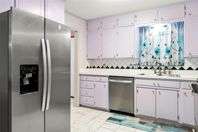 kitchen featuring a sink, marble finish floor, appliances with stainless steel finishes, light countertops, and tasteful backsplash