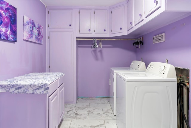 clothes washing area featuring marble finish floor, cabinet space, and washing machine and clothes dryer