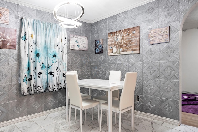 dining area with marble finish floor, crown molding, and an inviting chandelier