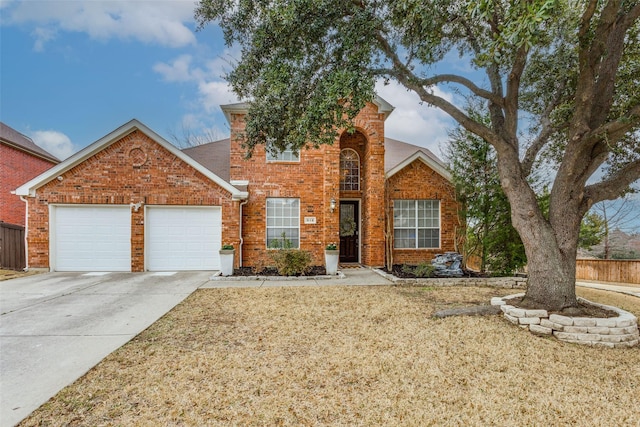 traditional home with a garage, brick siding, concrete driveway, fence, and a front yard