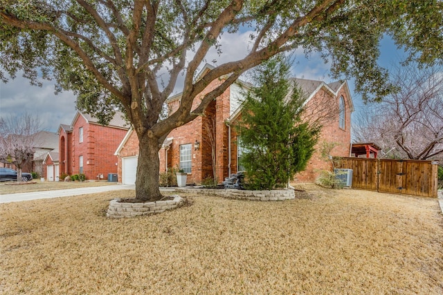 view of front facade with driveway, a garage, central AC unit, and brick siding