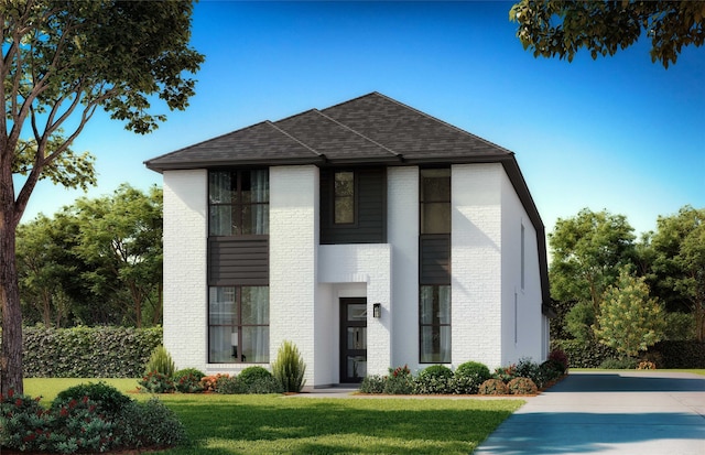 view of front of house featuring roof with shingles, a front yard, and brick siding