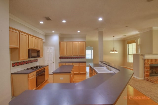 kitchen featuring a spacious island, dark countertops, visible vents, a sink, and black appliances