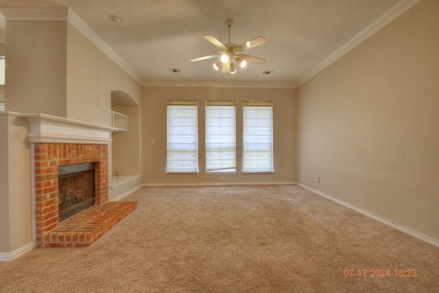 unfurnished living room featuring ceiling fan, a fireplace, carpet flooring, baseboards, and ornamental molding