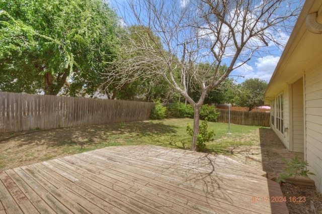 deck featuring a fenced backyard and a lawn